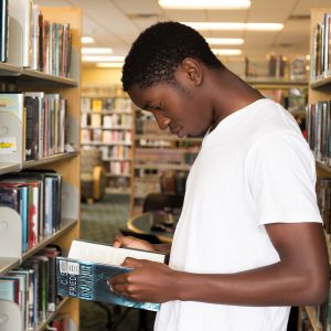 Young man reading a book at the library
